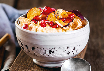 Reis-Porridge mit karamellisierten Zwetschken und Granatapfelkernen Foto: © Stocksy United