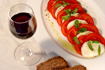 Mozzarella mit Paradeisern und Basilikum (Salat Caprese) und Rotwein